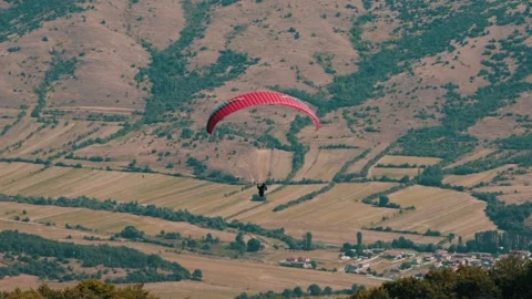 Gliding pilot peacefully soaring through the air with his paragliding wing. Video stock 266258202