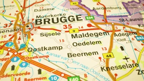 Gliding shot over atlas map highlighting road routes to brugge,belgium Video stock 344639946