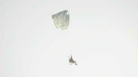 Gliding through the sky with motorized parachute at sunset 4K Stockbeeldmateriaal 257792447