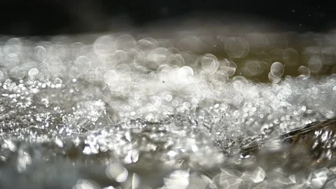 Glimmering bokeh effects from backlight on the water from a mountain stream Stock-Footage 219640554