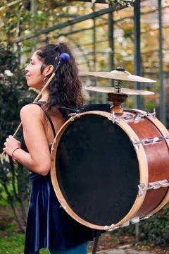 A glimpse of a dark-skinned Latin woman with her drum and cymbals on her back Stock Photos