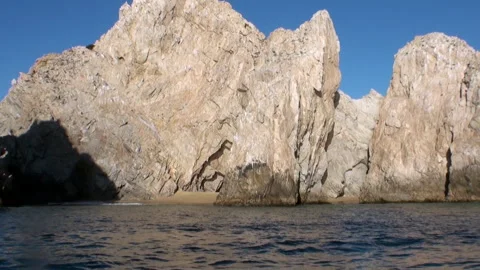 Glimpse of Lovers Beach through rocky cliffs in Cabo San Lucas Stock Footage 312529674