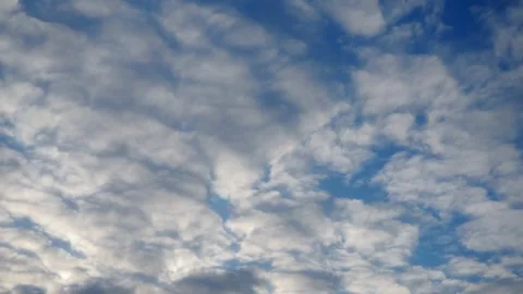Glimpses of fluffy, white clouds drift gracefully against blue Video stock 331462972
