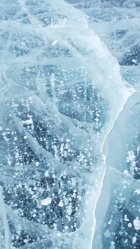 Glistening Ice Patterns and Bubbles Underfoot on a cold and beautiful winter day Stock Footage 310395323
