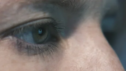 Glitch skull symbol reflected in eye iris of female person in front of screen Stock Footage 147678372