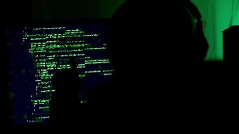 Glitching code on matrix flickering green dark screen, hacker with hood watches Stock Footage 297674919