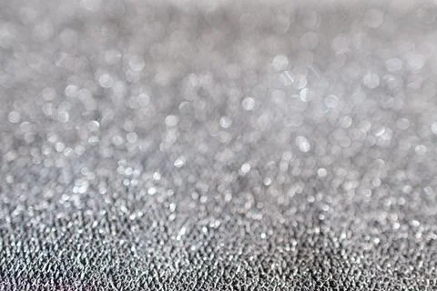 Glitter background in delicate metallic silver tones out of focus. Stock Photos