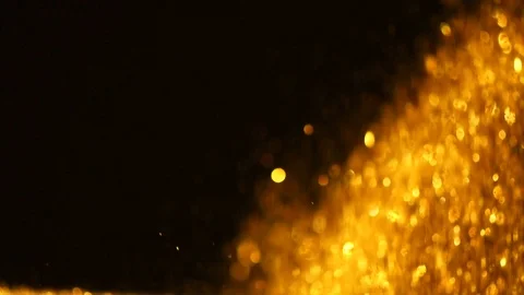 Glitter exploding golden sparkles isolated on black background.Gold glitter dust Stock Footage 99756055