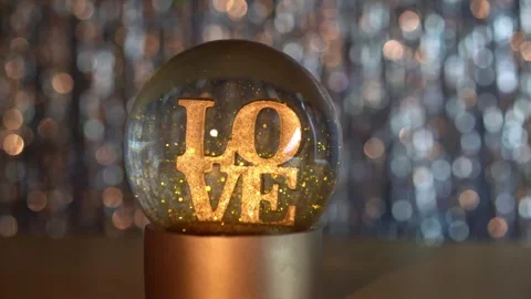 Glitter globe with the word LOVE with floating sparklings on the golden shining Stock Footage 247272814