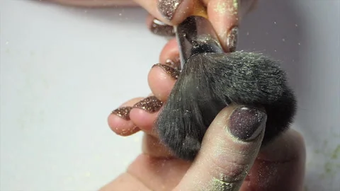 Glitter on makeup brush flying away with woman snapping her finger in slow Stock Footage 228436974