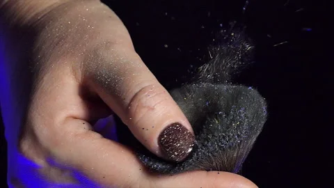 Glitter on makeup brush flying away with woman snapping her finger in slow Stock Footage 228606868