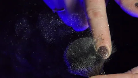 Glitter on makeup brush flying away with woman snapping her finger in slow Stock Footage 229296922