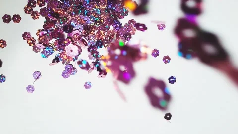 Glitter sequins slowly falling slow motion on white background Stock Footage 157002145
