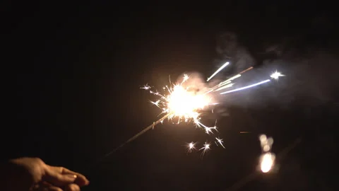 Glittering burning sparkler on black background Stock Footage 149873064