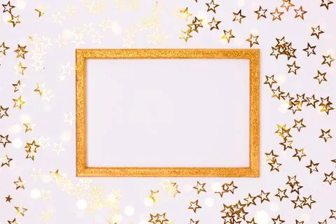 Glittering empty frame with gold stars confetti. Stock Photos