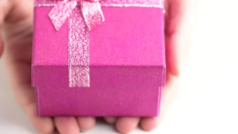 Glittering pink gift box, close up. Hands put a gift box on the table, pres.. Video stock 254887458