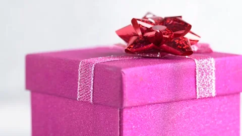 Glittering pink gift box with a red bow rotates. Birthday party or Christma.. Stock Footage 254326083
