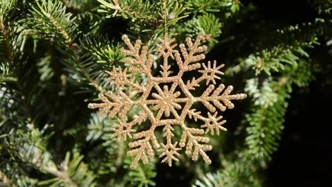 Glittering snowflake ornament turning in a Christmas tree Stock Footage