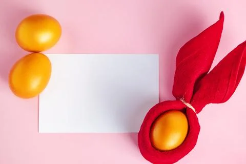 Glittery golden Easter eggs and blank greeting card on pink background. Foto stock