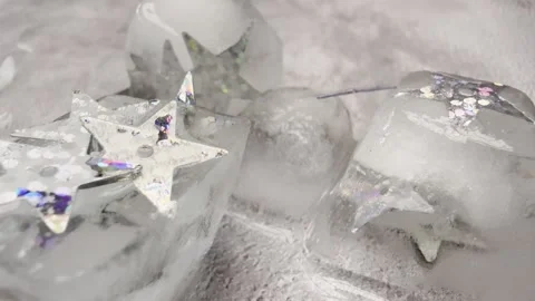 Glittery Silver Star Sequins on Melting Ice with Pouring Water Stock Footage 333555594