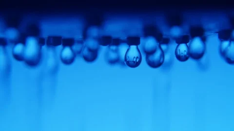 Glitzering drops of water streaming from a metallic spray in a modern blue Vídeo Stock 88286097