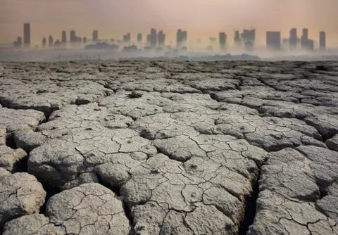 Global Warming and pollution theme with cracked land and the cityscape Stock Photos