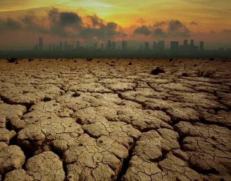 Global Warming and pollution theme with cracked land and the cityscape Stock Photos