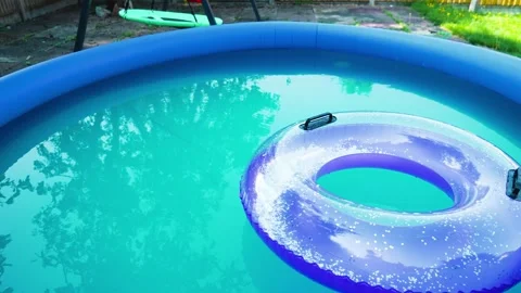 Global warming heatwave relief. Inflatable pool and floating swim ring reducing Stock Footage 339343920