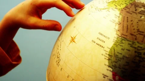 Globe and Childs Hands - 4k Stock Footage 71109502