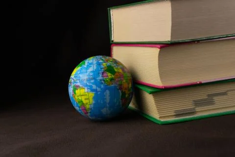 A globe and a stack of old books Stock Photos