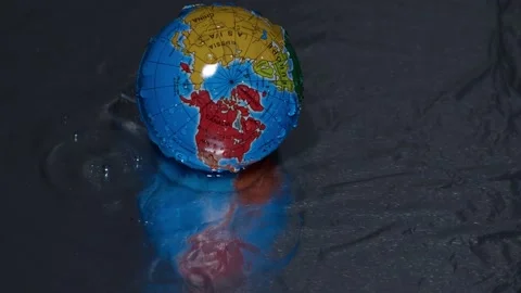 Globe on a dark background in the water in the rain Stock Footage 151967320