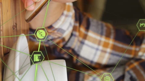 Globe of digital icons against mid section of man using smartphone and drinking Stock Footage 312320339