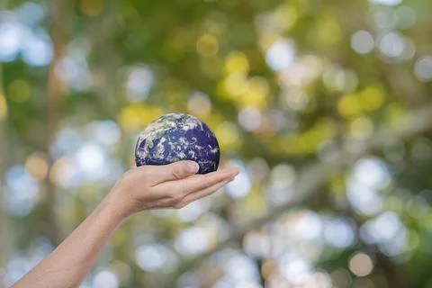 Globe, earth in human hands over green nature background. Stock Photos