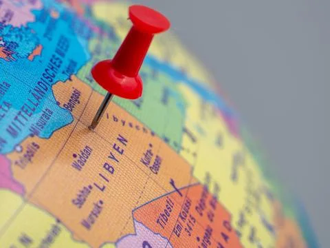 The globe indicates the country of Libya with a push pin. Stock Photos