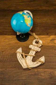 Globe model with old white anchor on wooden background Stock Photos