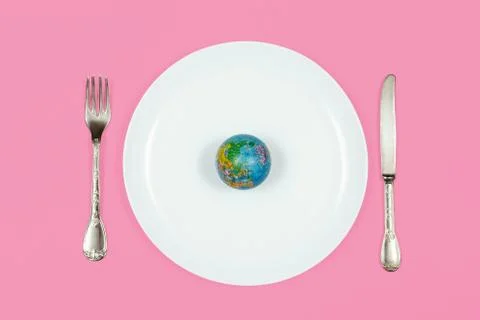 Globe model placed on empty plate with fork and knight Stock Photos