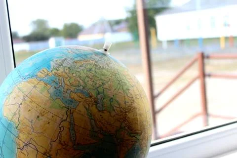 Globe with a physical map is on the windowsill Stock Photos