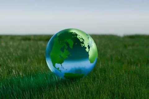 A globe representing Earth sits on green grass Illustrazione stock