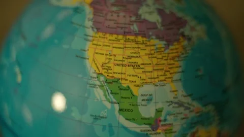 Globe rotates slowly, showing continents and oceans. Bright lights reflect off Stock Footage 342351644