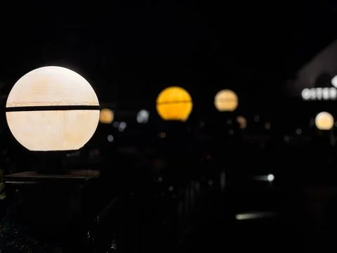 Globe-shaped lantern sitting atop a wooden post in an outdoor garden Stock-Fotos