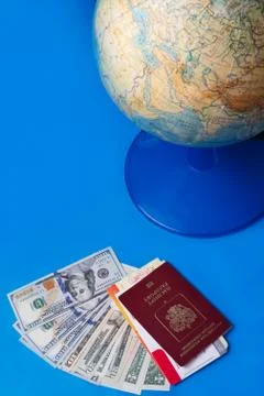 Globe sphere orb model effigy with passport, tickets and dollars around  blue Stock Photos