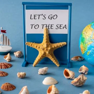 Globe, starfish and shells on a blue background with typography Let's go to t Stock Photos