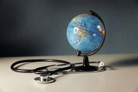 Globe with stethoscope on a grey background Stock Photos