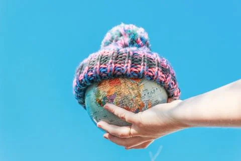 Globe in a warm hat. Planning a trip around the world. Stock Photos