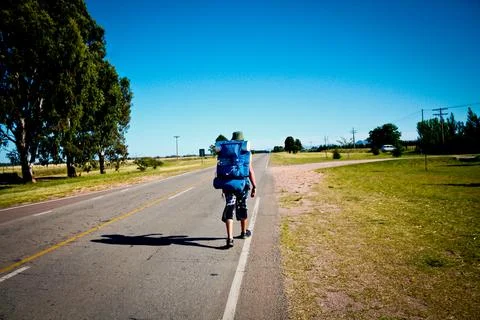 Globetrotter Boy with backpack walking down a street Stock Photos