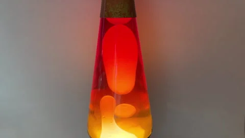 Globs of heated wax moving slowly in a novelty motion lamp Stock Footage 328880886
