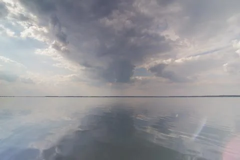 Gloomy clouds on smooth water surface landscape photo Foto stock