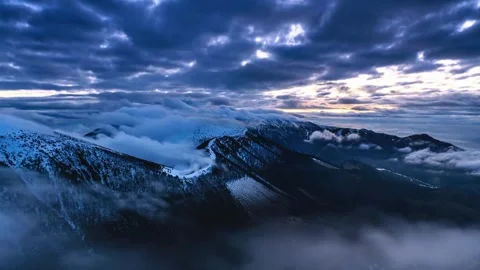 Gloomy cloudy sky over snowy mountain peaks motion footage. Stock Footage 341133285