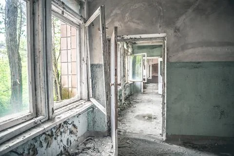 Gloomy corridor with broken window frames and debris Stock Photos