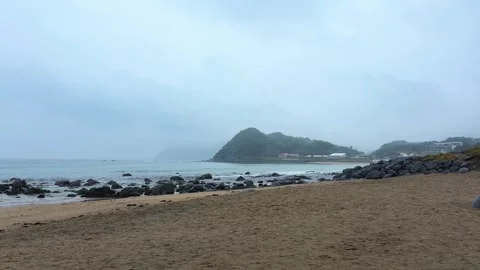 A gloomy view opens up over the sandy and rocky beach in Itoshima, Fukuoka. Stock-Footage 335694336